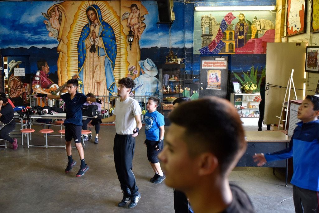 Children of all ages do warm-up exercises before they begin their boxing lesson at Casa...