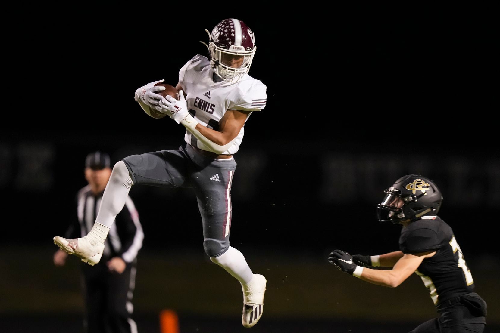 Ennis wide receiver Gracen Harris (14) makes a leaping catch as Royse City defensive back...