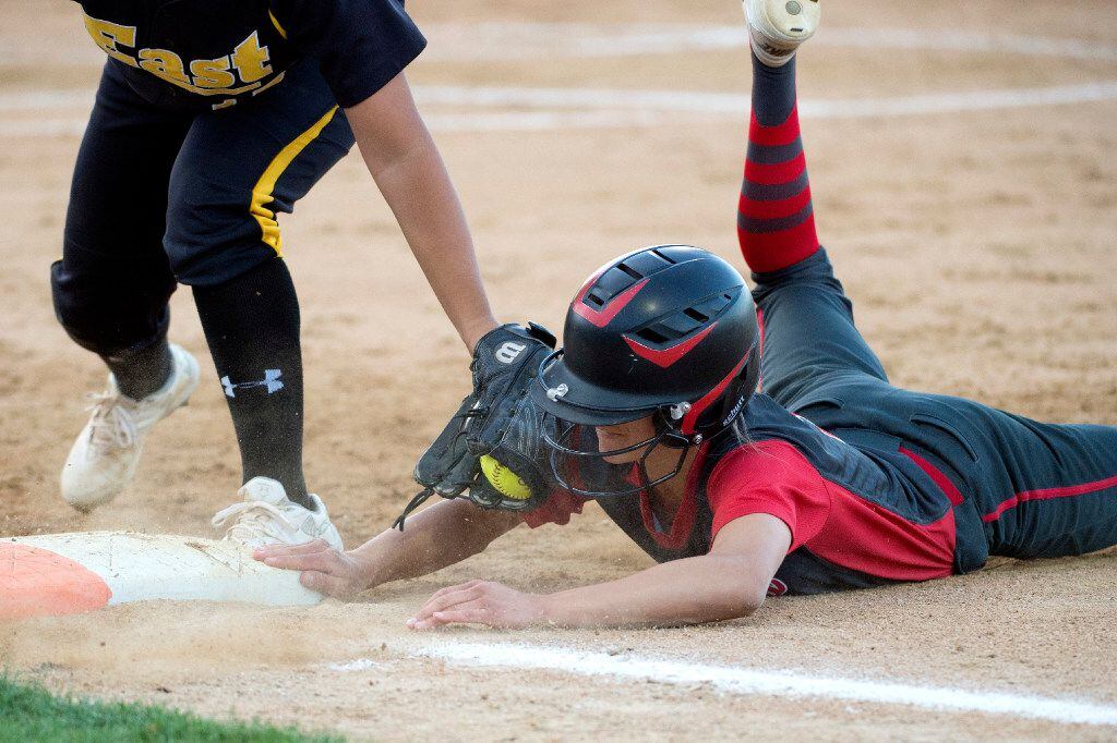 Flower Mound Marcus senior catcher Kendra Hess (13) dives safely back to first base ahead of the tag of Plano East junior first baseman Gabriela Lopez (15) in the second inning of a high school softball game, Thursday, April 27, 2017 in Flower Mound, Texas. (Jeffrey McWhorter/Special Contributor)
