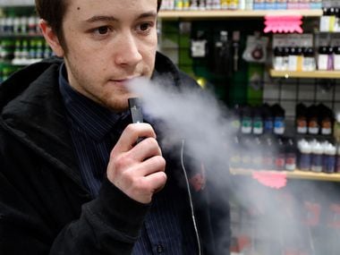 Nick Gregory, a 26-year-old manager, vapes on a JUUL at Botany Bay in Lexington, Ky. Several...