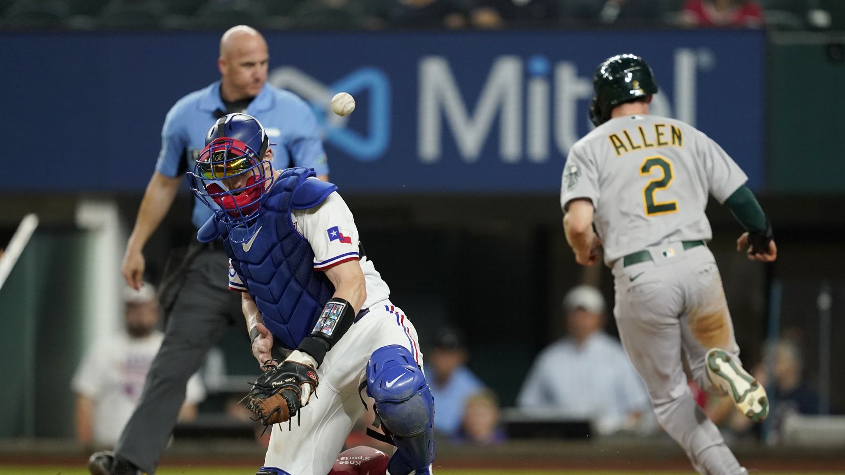 The ball gets away from Texas Rangers catcher Sam Huff as Oakland Athletics' Nick Allen...