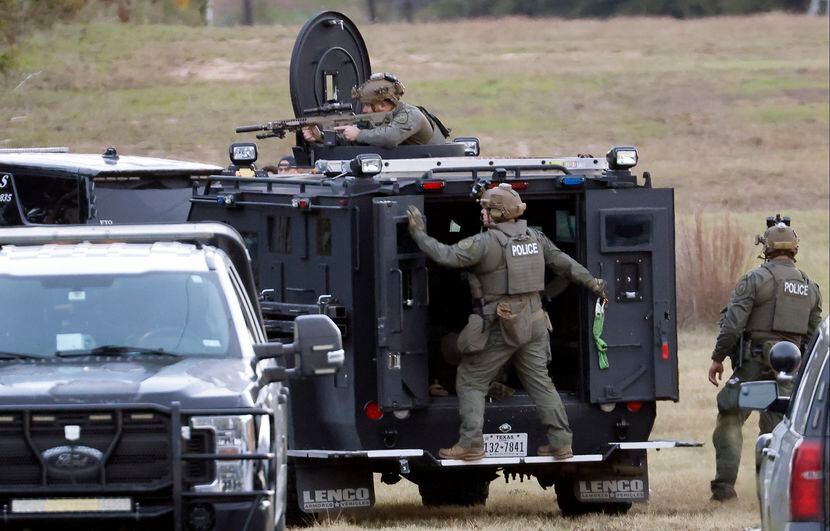 Fort Worth police SWAT officers take up a position on the backside of Lynnwood Hills Drive,...