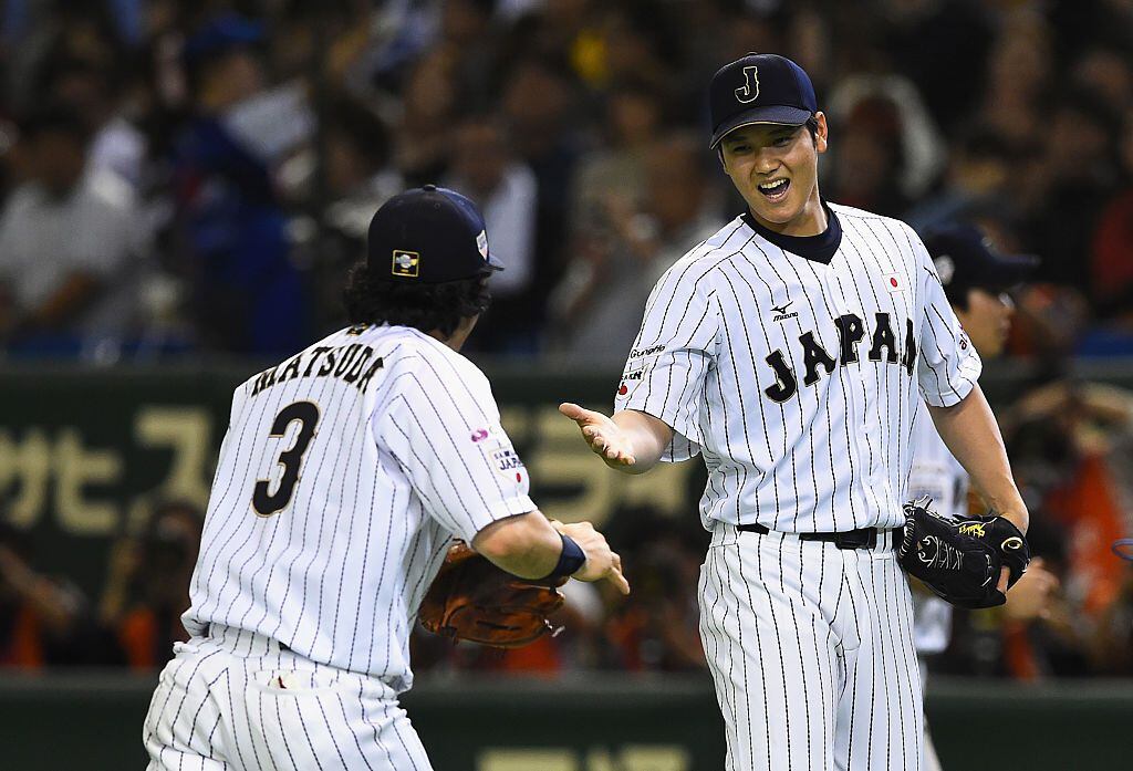 TOKYO, JAPAN - NOVEMBER 19:  Starting pitcher Shohei Otani (R) #16 of Japan high fives with...