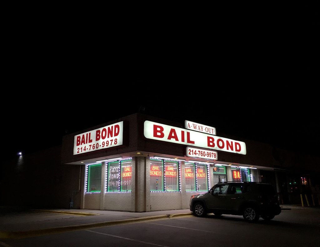 Lights from a bail bond business glow along Riverfront Boulevard in Dallas.