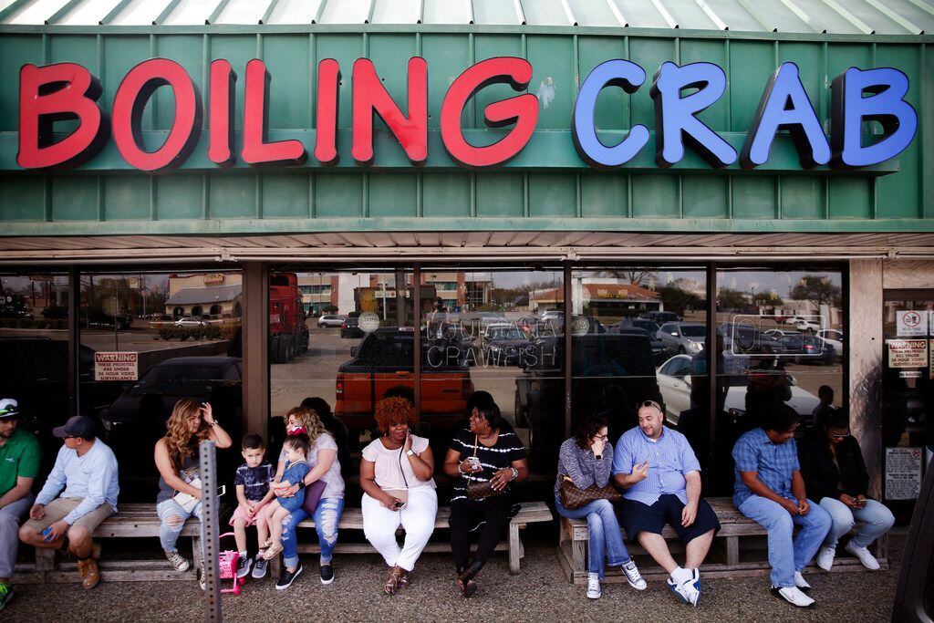 People wait in line for lunch at The Boiling Crab in Dallas.
