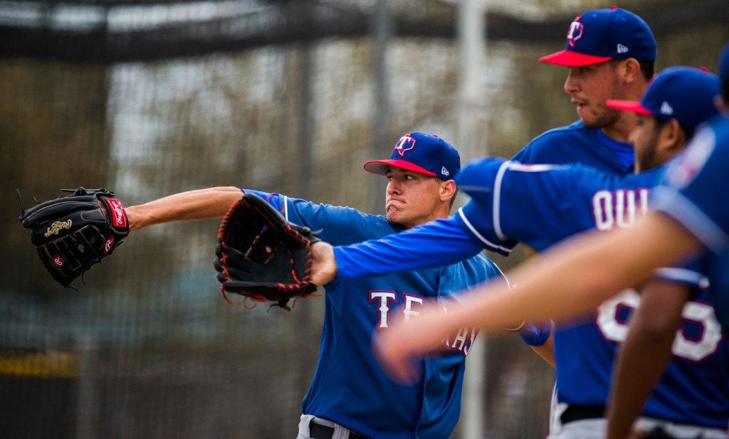 FILE - Pitcher Brett Martin (center, background) pitches in the bullpen during a spring training workout at the Rangers' training facility on Sunday, March 5, 2017, in Surprise, Ariz. (Ashley Landis/The Dallas Morning News)