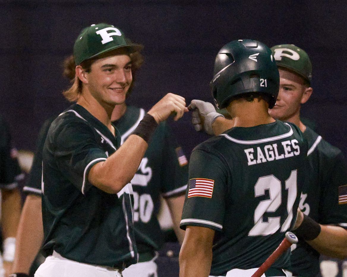 Prosper’s Zach Howell (21) fist bumps Austin Rogers (4) after scoring a run against Coppell...