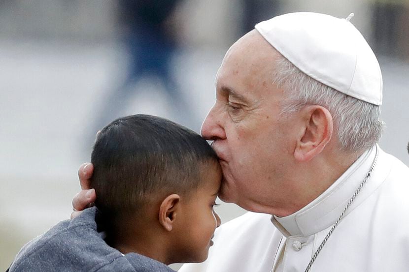 El papa Francisco besa a un niño en la frente al llegar a la Plaza de San Pedro, en el...