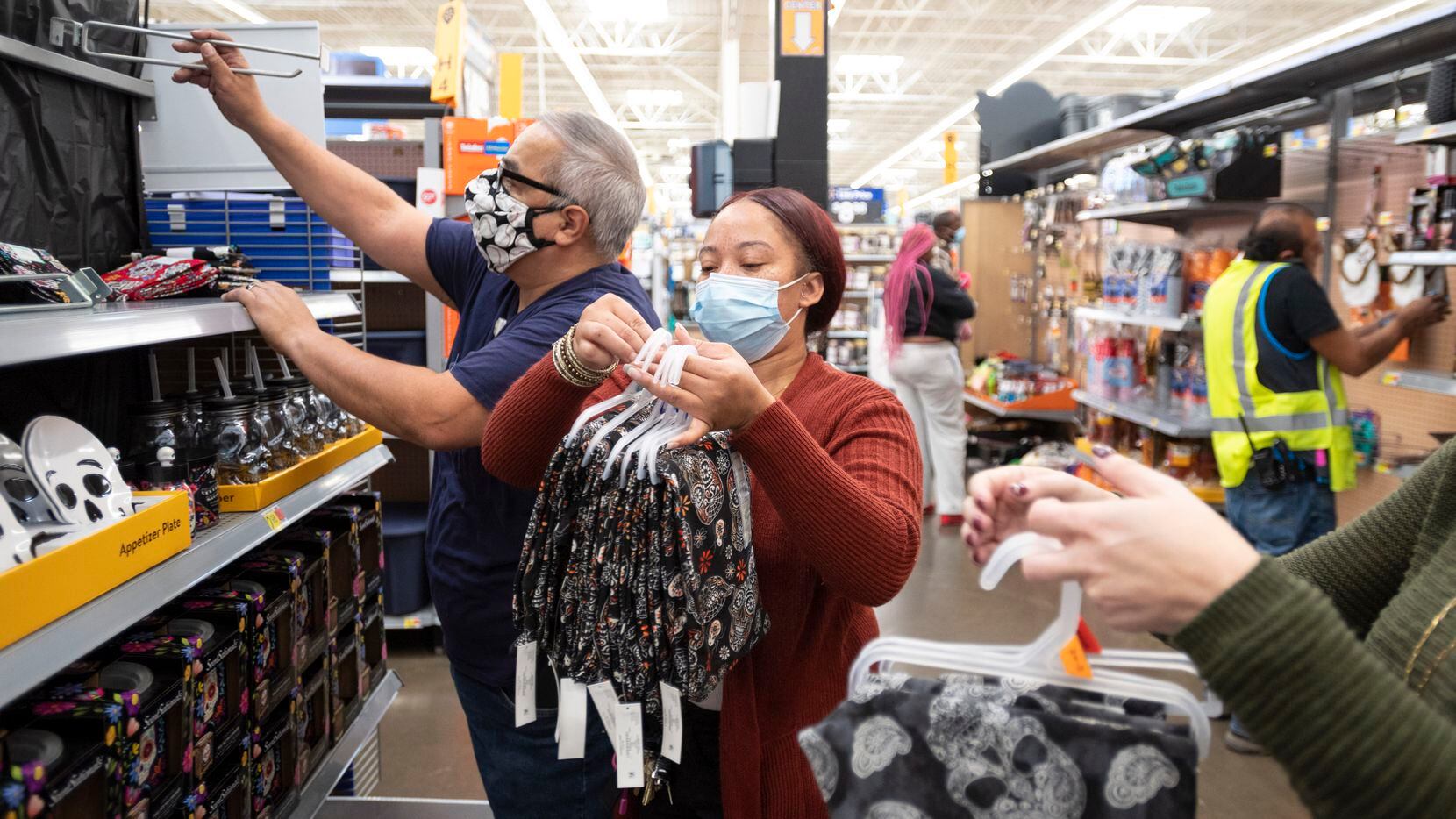 Walmart employees Roberto Bustos, left, and Ron Adams, center, re stock a shelf with their...