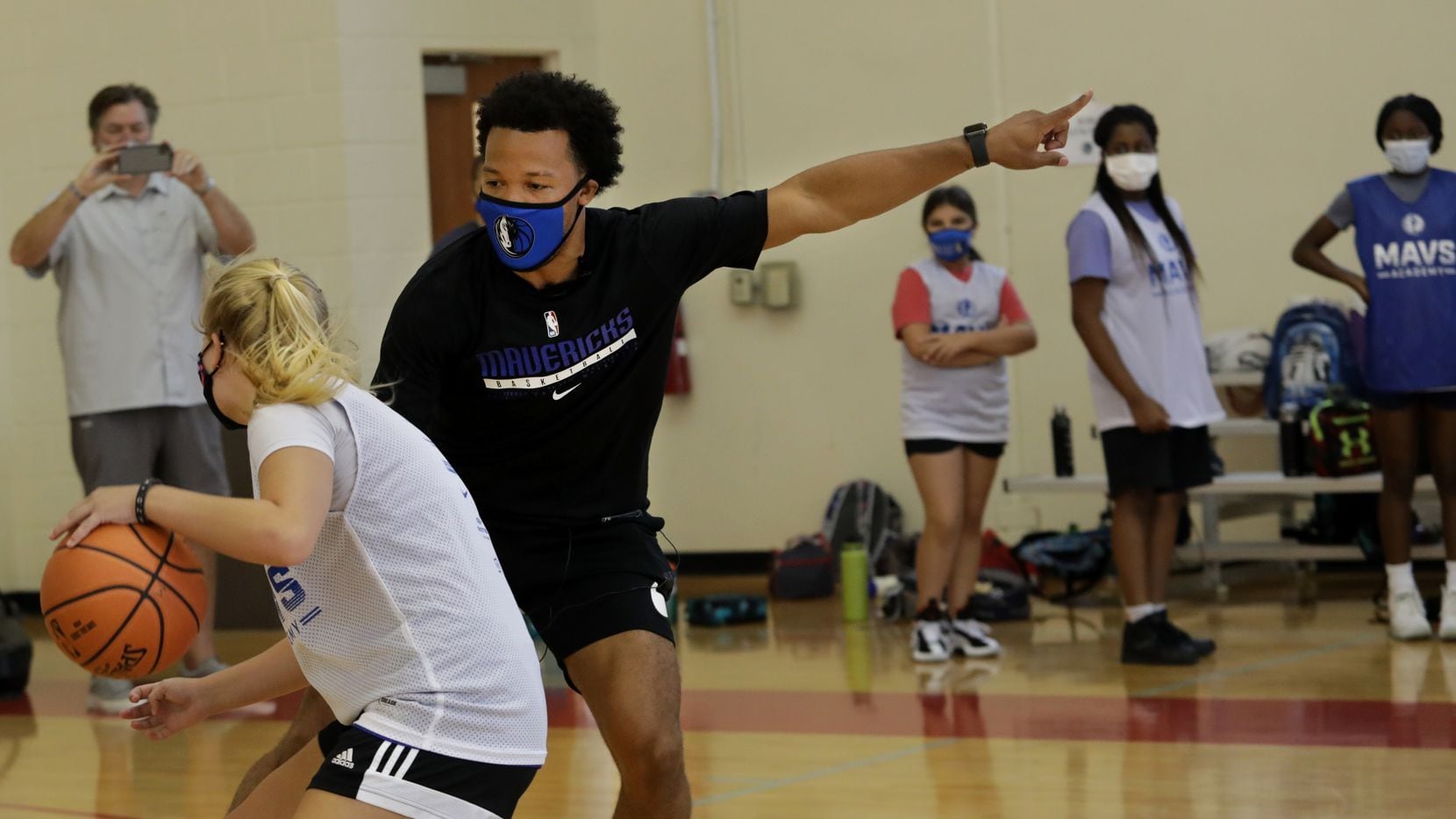 15-year-old Charlotte Collins, left, goes head to head with Jalen Brunson as he interacts with young basketball players during the Mavs Academy Hoop Camp at the Frisco Athletic Center in Frisco, TX, on Jul. 27, 2021.