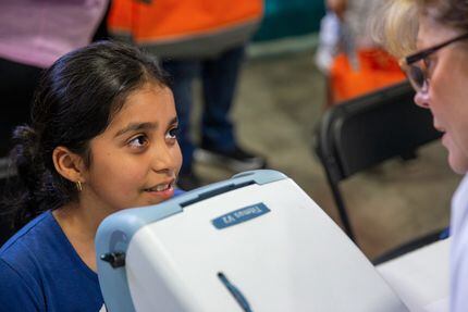 Genesis Campos, de 9 años, recibe un examen de visión durante la Feria de Regreso a Clases...