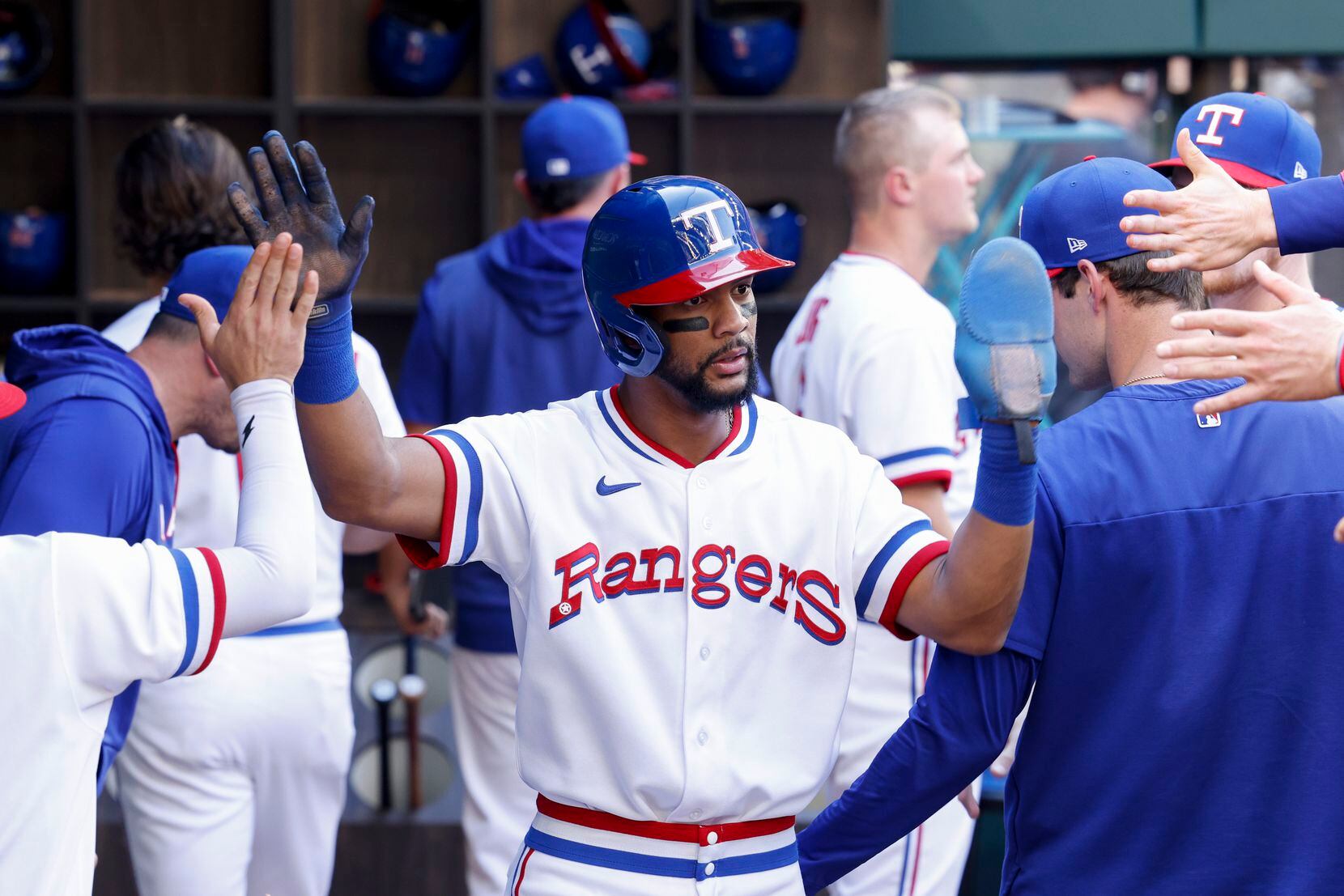 Texas Rangers center fielder Leody Taveras (3) celebrate a run with teammates in the dugout...