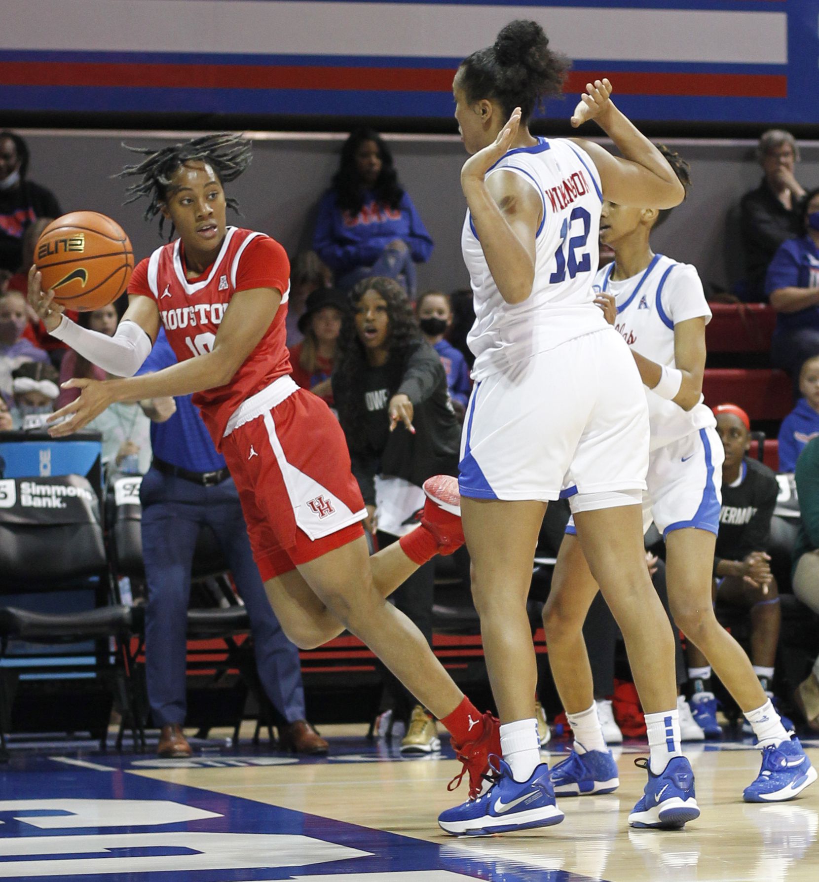 Houston guard Britney Onyeje (10) gets an off-balance pass off around the defense of SMU...