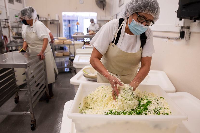 Carmen Lopez mixes jalapeño and epazote herb into queso blanco as she prepares a variety of...