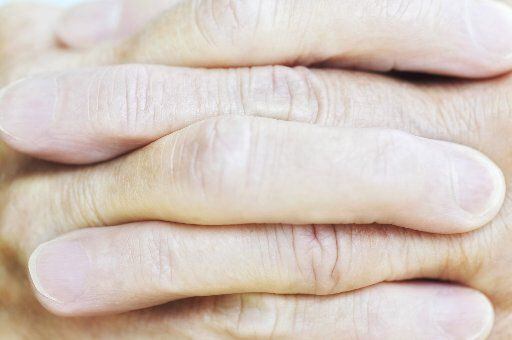 ORG XMIT:  Cropped Close-up of Woman's Clasped Fingers