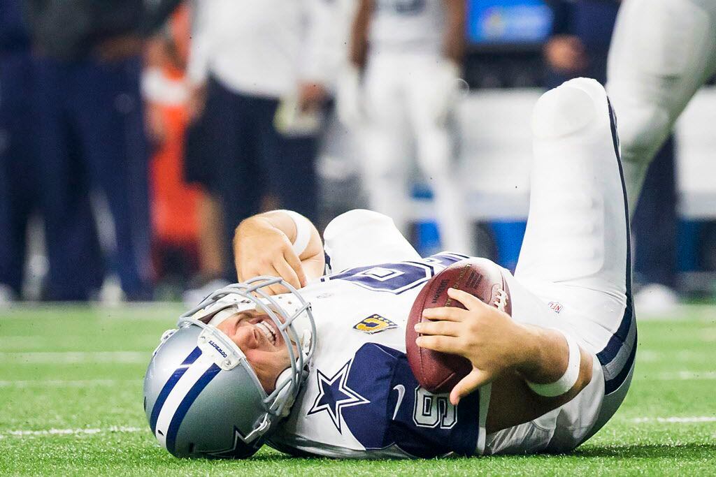 Dallas Cowboys quarterback Tony Romo (9) grimaces as he rests on the turf after being sacked by Carolina Panthers outside linebacker Thomas Davis during the second half of an NFL football game at AT&T Stadium on Thanksgiving Day, Thursday, Nov. 26, 2015, in Arlington. Romo left the game with an re-injuring his left shoulder on the play. (Smiley N. Pool/The Dallas Morning News)