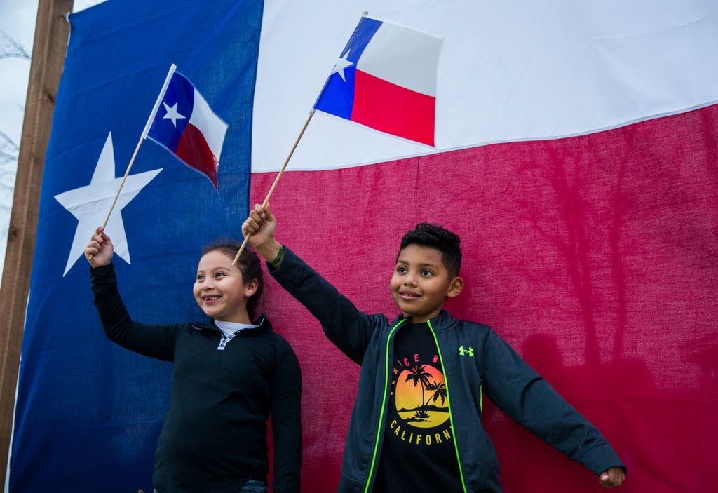 Gianna Bocanegra, left, and Chris Madrid pose for photos with Texas flags at TexFest on...