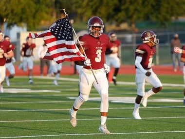 Heritage High School wide receiver Jordan Gregory (3) carries the United States flag as the team attempts to social distance as they take the field before kickoff as Heritage High School hosted Rock Hill High School at Memorial Stadium in Frisco on Thursday night, September 24, 2020.