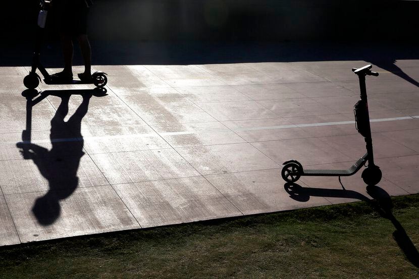 ARCHIVO – En esta foto de archivo del 28 de mayo de 2019, un hombre en patinete pasa junto a...