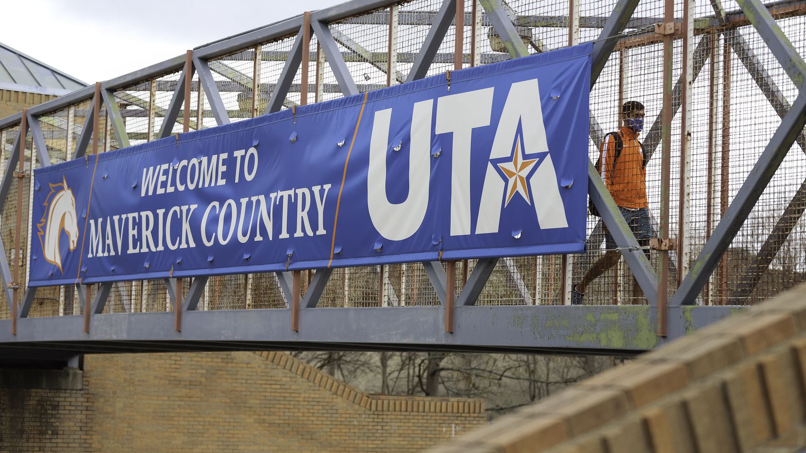 A student crosses a bridge on The University of Texas at Arlington campus Friday, March 12,...