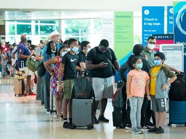Passengers in line to check in for a flight at Dallas Love Field Airport on Monday, July 25,...