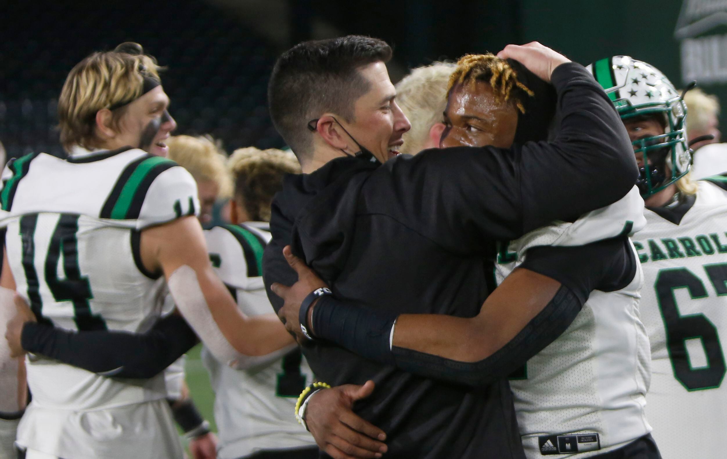 Southlake head coach Riley Dodge shares a hug with Dragons defensive back Cinque Williams...