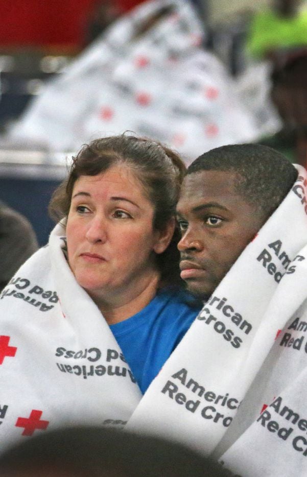 Displaced South Houston residents Oralia Guerra and Diamond Robinson huddle together to stay warm underneath Red Cross blankets at the George Brown Convention Center in  Houston on Monday, August 28, 2017, in the wake of Hurricane Harvey. (Louis DeLuca/The Dallas Morning News)