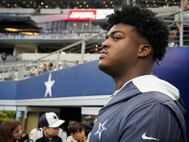 Dallas Cowboys offensive tackle Tyler Smith watches teammates warm up before an NFL...