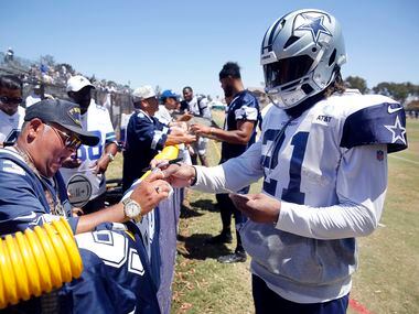 Dallas Cowboys running back Ezekiel Elliott (21) signs autographs for retired Army veteran...