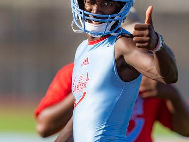Carter wide receiver/tight end Niko Johnson gives a thumbs up to a teammate during the first...