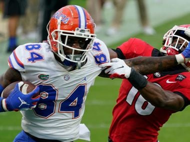 FILE - Florida tight end Kyle Pitts (84) tires to get past Georgia defensive back Lewis Cine (16) after a reception during the first half of an NCAA college football game in Jacksonville, Fla., in this Saturday, Nov. 7, 2020, file photo.