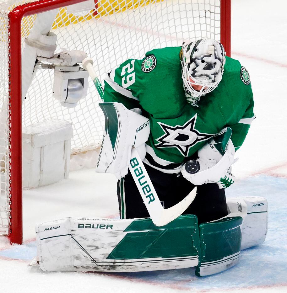 Dallas Stars goaltender Jake Oettinger (29) stops a first period shot by the Calgary Flames...