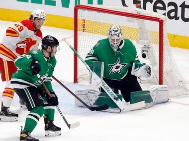 Dallas Stars goaltender Jake Oettinger (29) deflects a shot by Calgary Flames center Mikael...