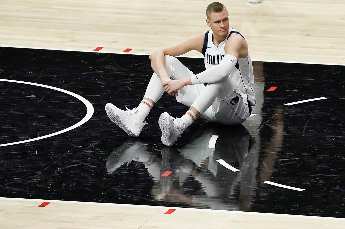 Dallas Mavericks center Kristaps Porzingis sits on the court after a foul during the second...