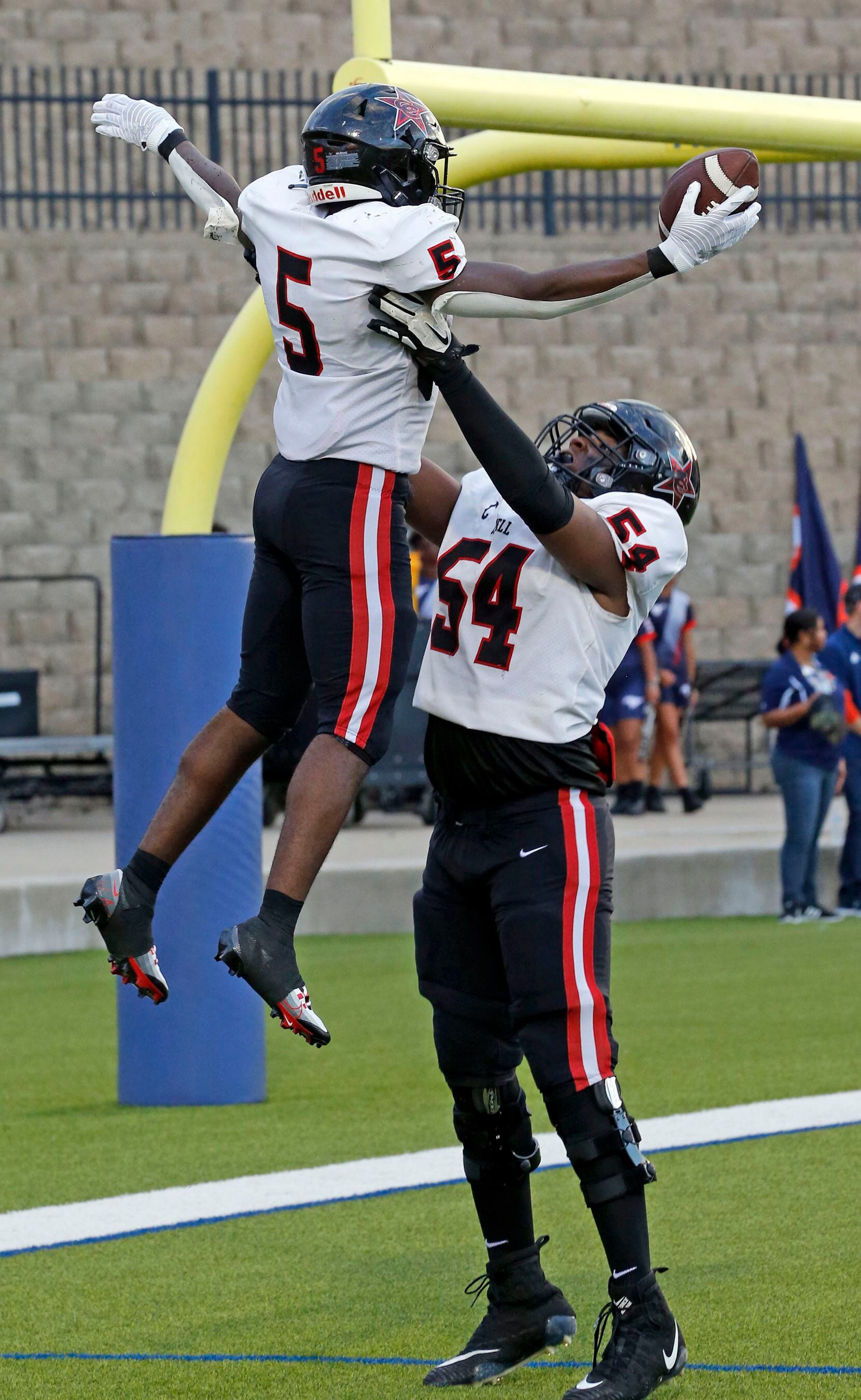Coppell RB Malkam Wallace (5) is held high in the air by teammate Chimdia Nwaiwu (54) after...