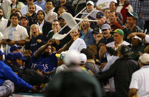 Texas Rangers reliever Frank Francisco, bottom left, hurls a ballboy's chair into the crowd...
