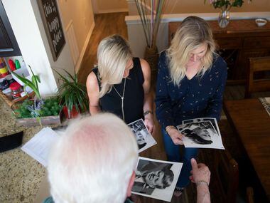 Kennedy presents Robbins (middle) and Leonard signed copies of the photo he took of their...
