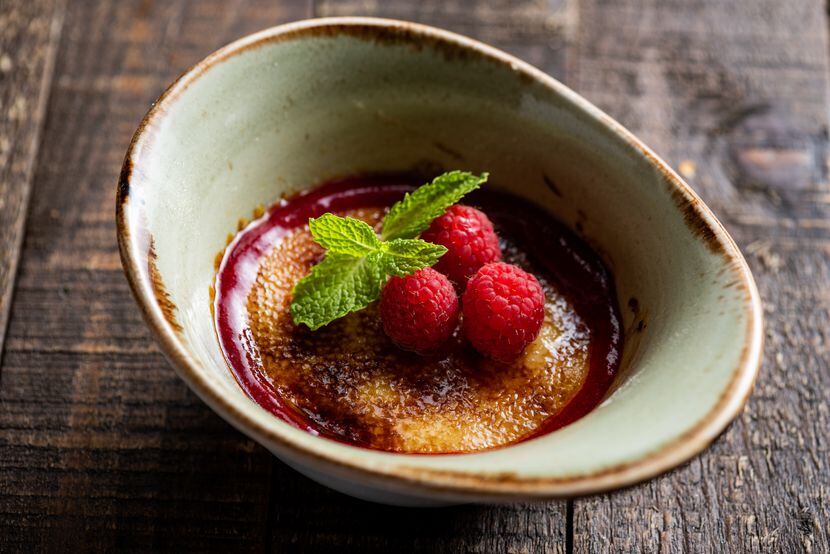 Cru Food and Wine Bar serves raspberry and vanilla bean creme brulee with raspberry sauce as...