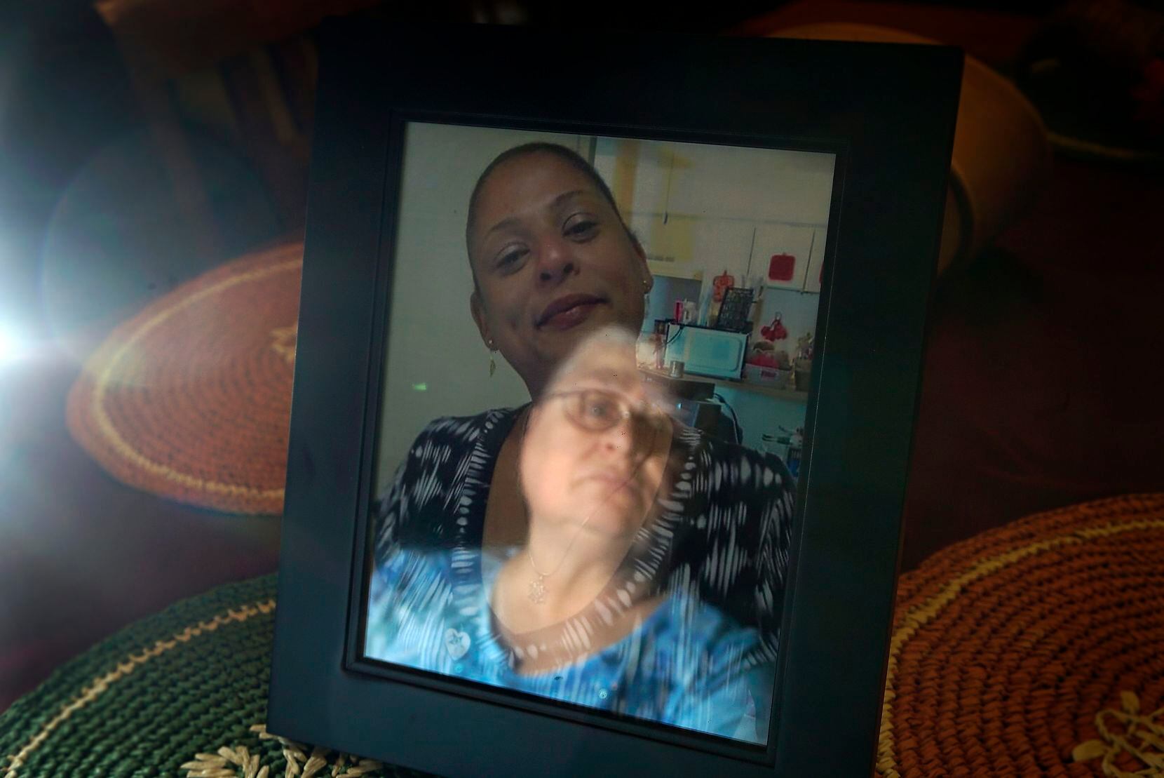 Debra McDonald face is reflected in a picture of her daughter Nicole McChriston, who was killed Sept. 4. Because Nicole  dealt with bipolar disorder and other strains of mental illness for many years, she lived with her mother most of her life.