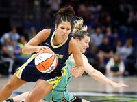 Dallas Wings guard Veronica Burton (12) falls to the ground after colliding with New York...