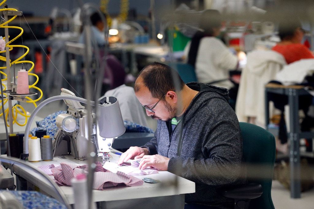 Visually impaired worker Felix Castaneda sews one of Dallas designer Tish Cox's fashions....