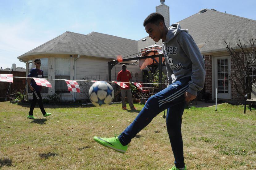 Miguel Kobby Adoboe entrena con un balón de futbol en el patio de su casa en Sachse, Texas,...