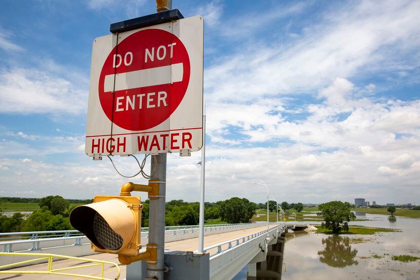 A closed sign on the road to Trammell Crow Park warning of high water from the Trinity River...