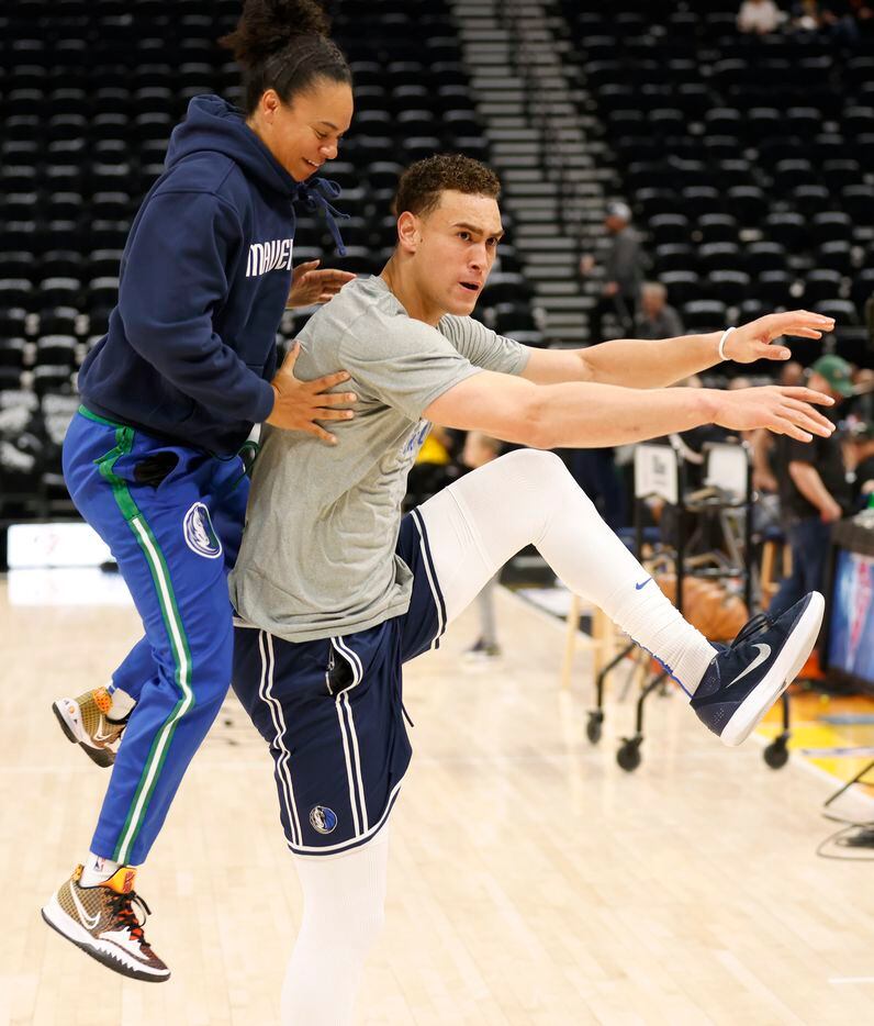 Dallas Mavericks assistant coach Kristi Toliver hops off the back of Dallas Mavericks center...