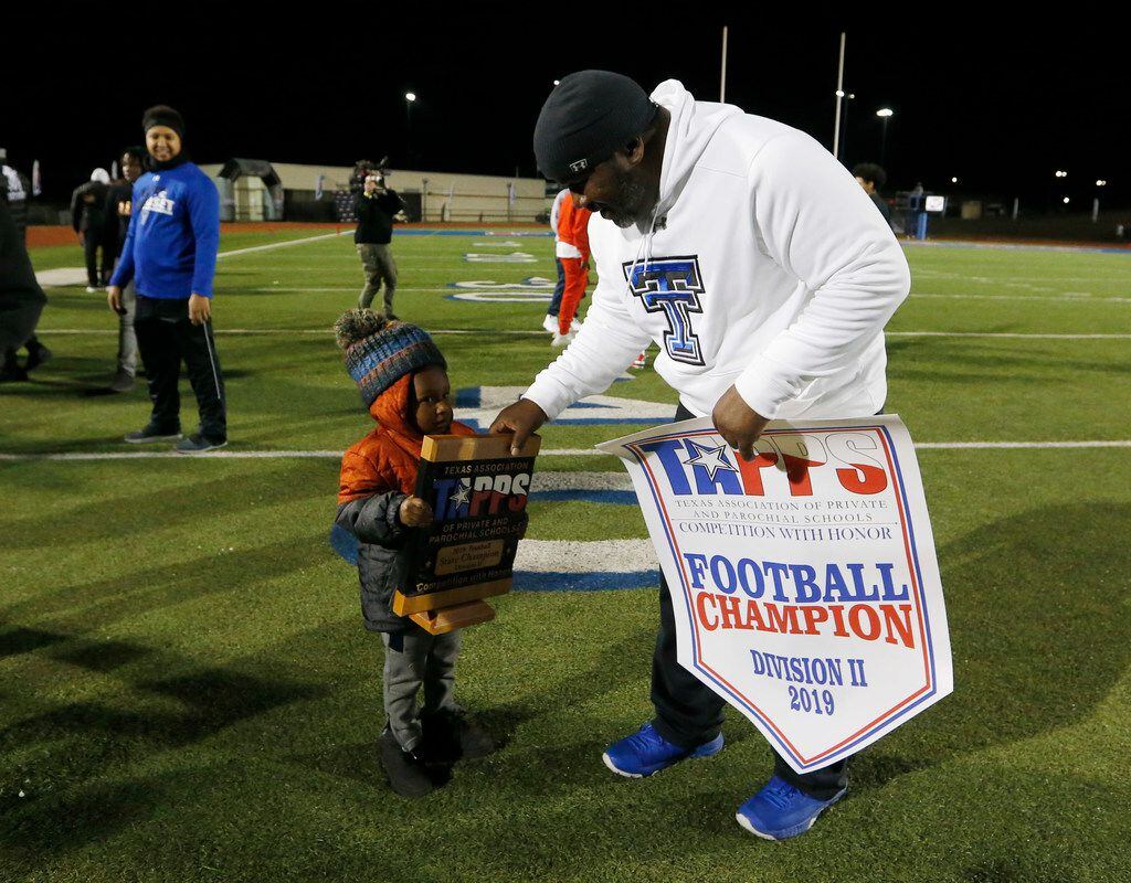 Trinity Christian's head coach Andre' Hart passes the trophy to his son Arrington Hart after they defeated Austin Regents 48-19 in the TAPPS Division II State Championship game at Waco Midway's Panther Stadium in Hewitt, Texas on Friday, December 6, 2019. Trinity Christian defeated Austin Regents 48-19. (Vernon Bryant/The Dallas Morning News)