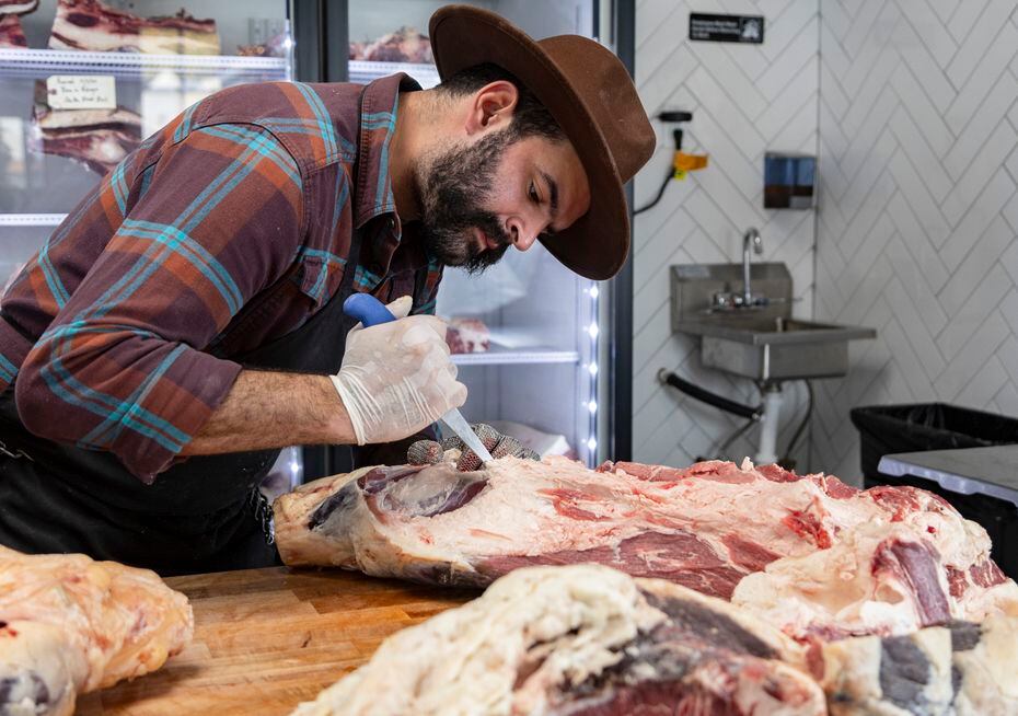 Raul Rubero, head butcher and manager, slices beef at Custom Meats in University Park.