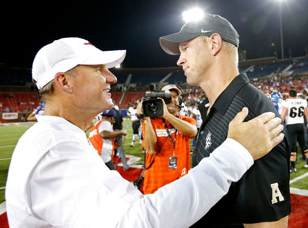 Southern Methodist head coach Chad Morris, left, talks with UCF head coach Scott Frost after...