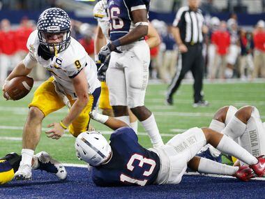 Highland Park's John Stephen Jones (9) scores a touchdown as he is tackled by Manvel's...