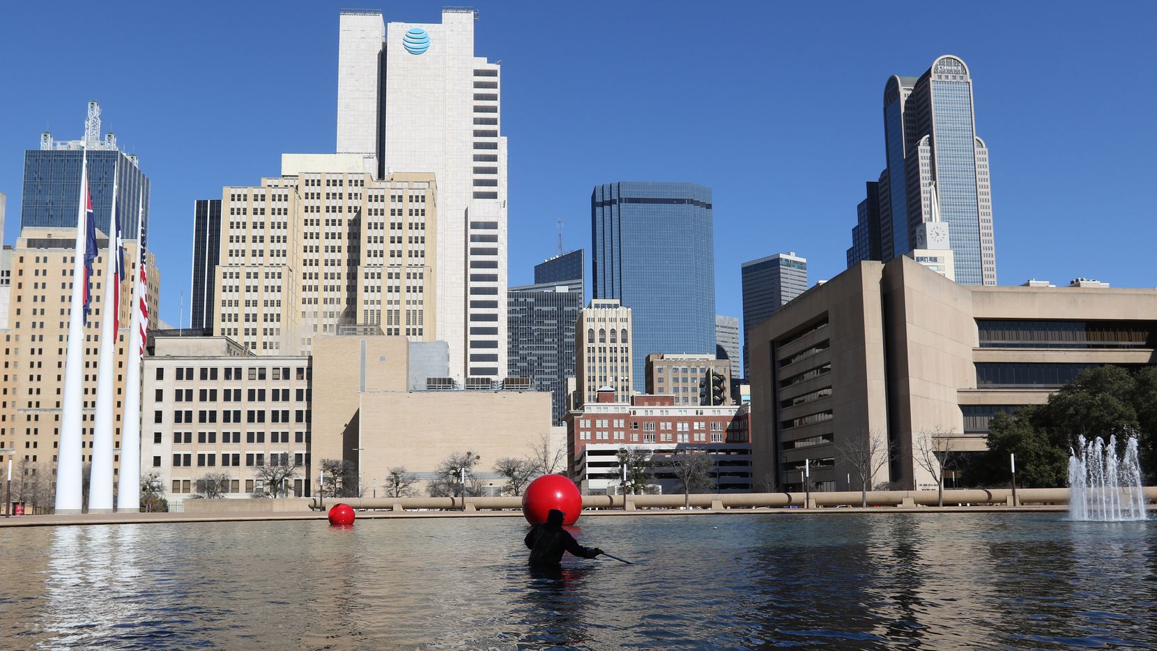City of Dallas employee Kenneth Argusta cleans the reflecting pool at Dallas City Hall in downtown Dallas, Tuesday, February 12, 2019. (Benjamin Robinson/The Dallas Morning News)