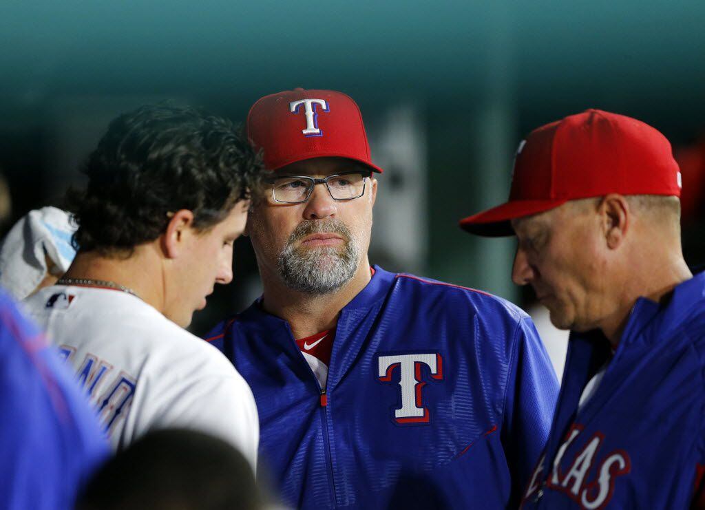 Texas Rangers pitching coach Doug Brocail (center) visits with starting pitcher Derek...